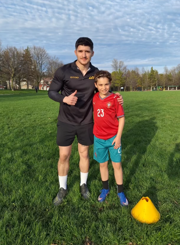 Coach Luca with a player on the pitch after training